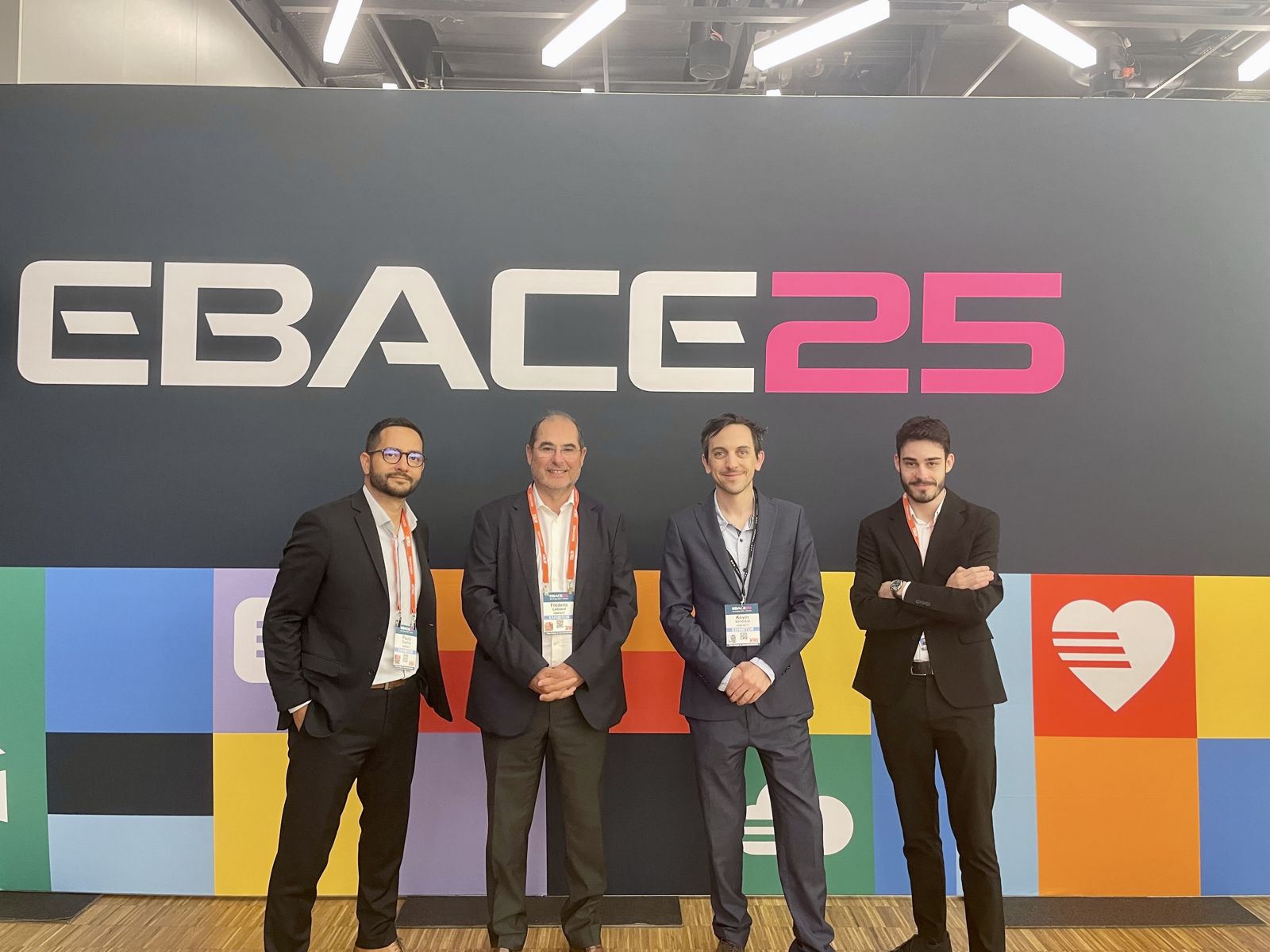 Four members of the Hinfact team in front of the EBACE 2025 sign in Geneva.